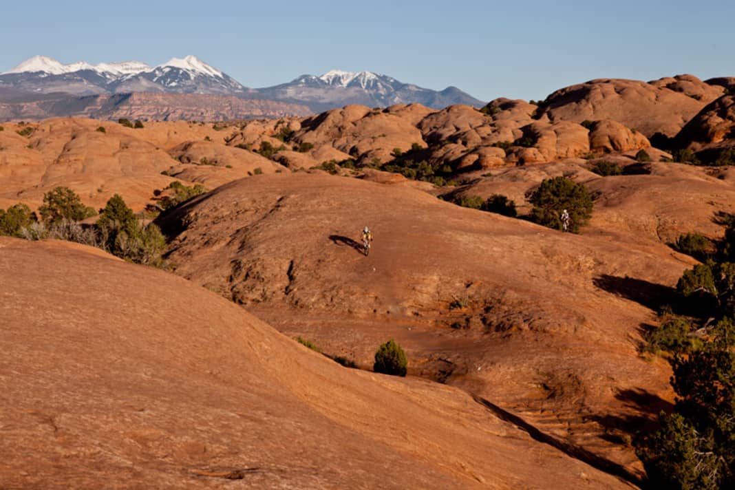 The slickrock trail lies there as if freshly swept. But only those who stay on the white line will make it back alive.