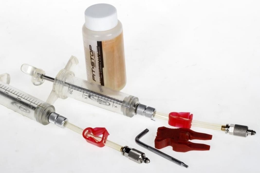 Bleeding kit for Avid, for example: two syringes, a 10mm and a 25mm Torx, a red spreader block and a bottle of DOT brake fluid

Syringes Robust syringes with stop and screw-on hose. The hose can be disconnected with a click valve.

Spreader block Conventional plastic block with bevelled edges to push the pistons apart. Alternative: Plastic tyre lever.