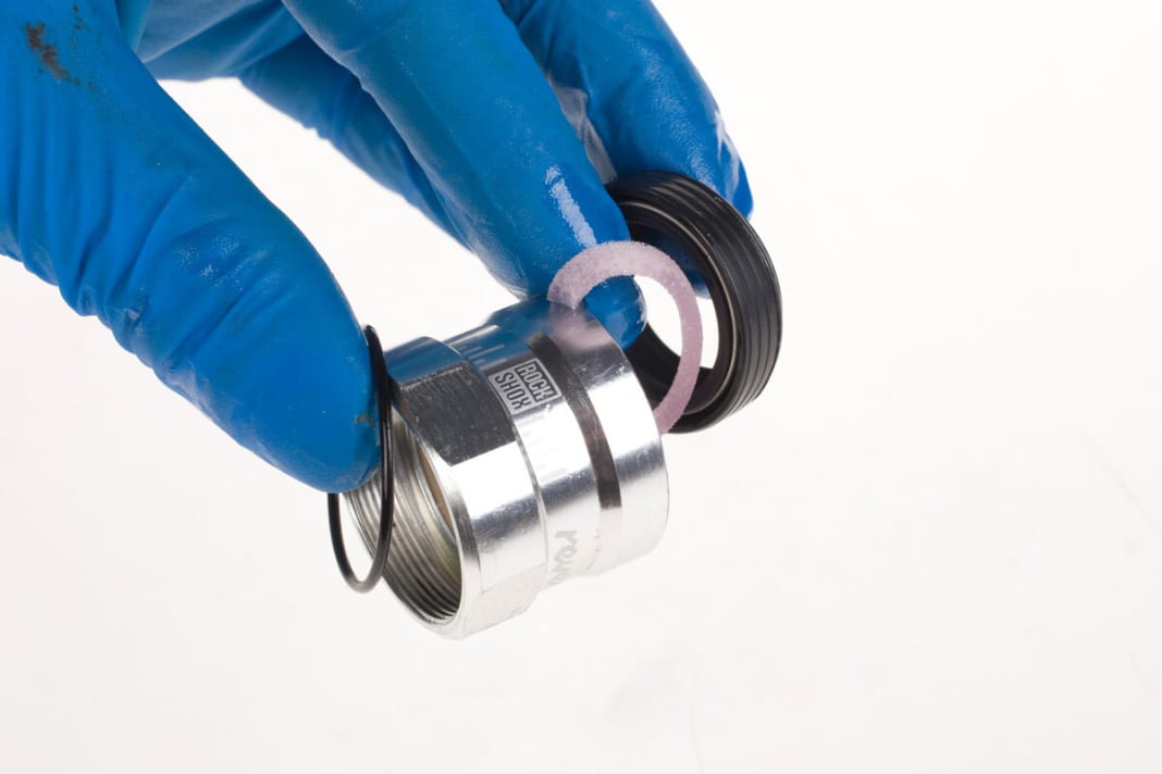 1. Tränken Sie den neuen Schaumstoffring mit 2,5W-Öl und setzen Sie diesen oben und den O-Ring unten ein. Anschließend wird die neue Staubdichtung oben in die Überwurfmutter eingepresst.