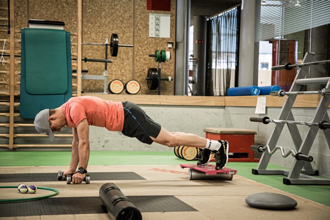 Strengthening exercise for the core, back and arms. This core exercise is relatively simple in the starting position, but enormously challenging as soon as the arm movement is added.

1 Starting position: Push-ups on a balance board (e.g. Sypoba) and two 3-kilo dumbbells. Simple push-ups are sufficient at the beginning.