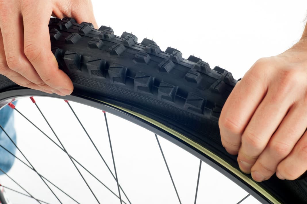 1. after a puncture, you must first completely loosen the bicycle tyre and press it into the rim well on one side. Only then can the tyre be levered outwards over the rim flange in the next step. 