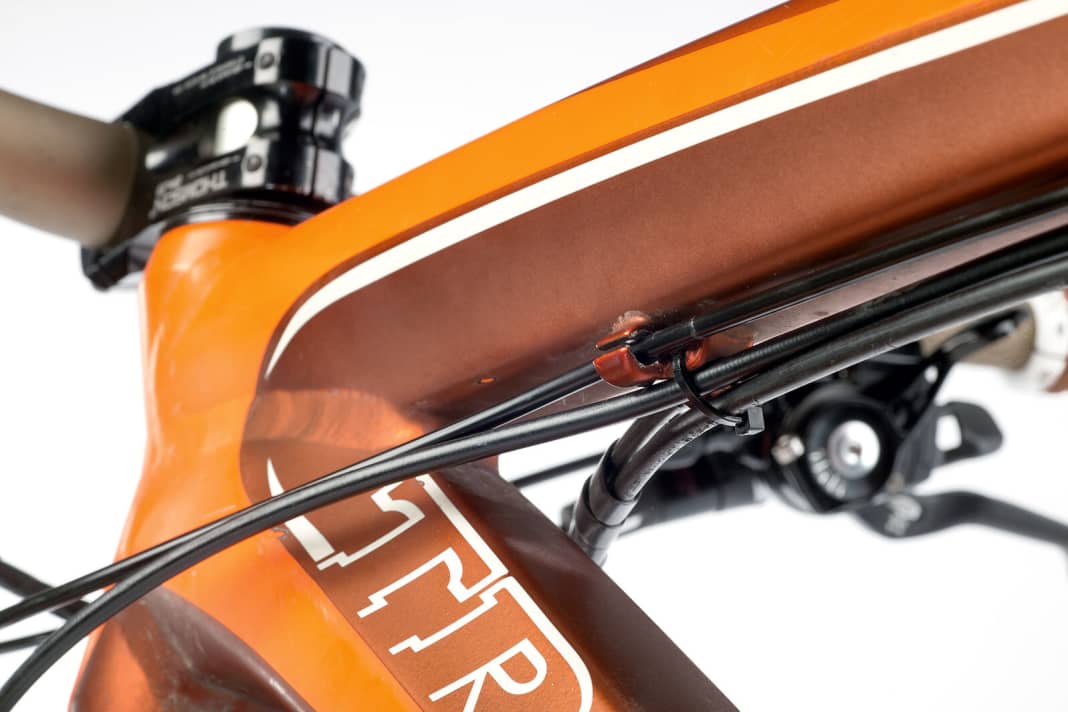 (6) Feintuning  Wem die Züge zu lose im aufgebohrten Anschlag liegen, der kann die Außenhülle an der entsprechenden Stelle mit Klebeband verdicken und den Zug so fixieren.