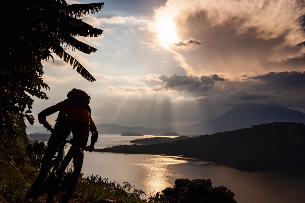 Das kleine zentralafrikanische  Land Ruanda hat seine finstere Vergangenheit  hinter sich gelassen und sieht  eine leuchtende Zukunft im Radsport.  Der britische Abenteuerfotograf Dan Milner hat  die Virunga-Vulkane erkundet und  ist dabei auf die wohl  größte Trail-Bau-Crew der Welt getroffen. 