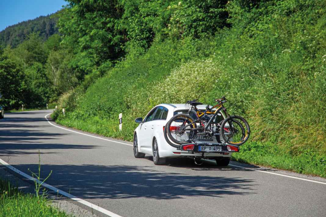 One way to take your bike on holiday is on the rear rack of your car - but there are other options and other means of transport.