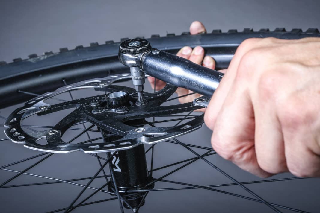 1 Sechs-Loch-Scheibe: Die Befestigung erfolgt über sechs Schrauben, die je nach Bremsenmodell mit einem Drehmoment von 4–6 Nm über Kreuz angezogen werden. Die Schrauben sind mit einer Schraubensicherung versehen, um ein ungewolltes Lösen der Bremsscheibe zu verhindern.