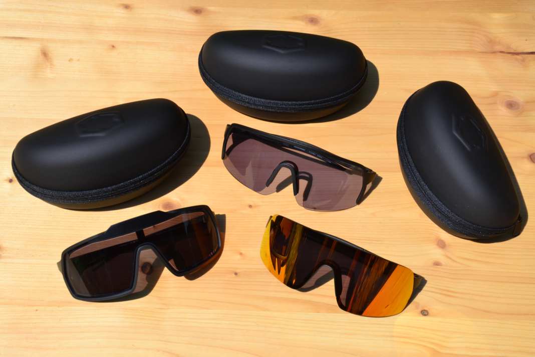 Drei frische Sonnenbrillen aus Italien liegen auf einem Holzbrett.