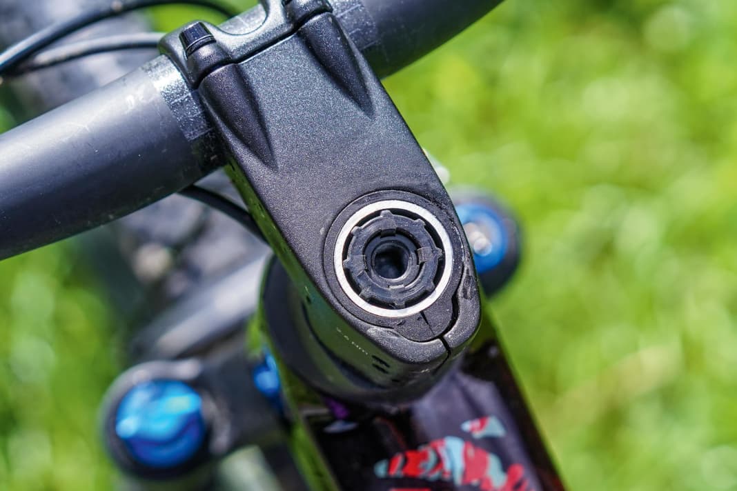 Nett anzuschauen, aber in der Praxis nervig: Der Fit Stem (hier ohne Abdeckkappe) beherbergt eine rätselhaft umständliche Steuersatzklemmung. Gut wiederum: Anstelle des Blindstopfens (Foto) kann ein optional  erhältliches Mini-Tool im Gabelschaft untergebracht werden. Zudem verfügt das Lynx über einen Lenkeinschlagsbegrenzer.