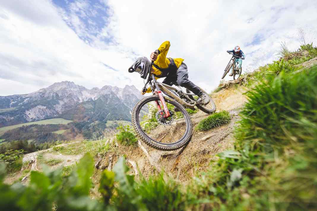Vergleichstest auf der Wordlcup-Strecke in Leogang. Tester Laurin drückt das Parkbike Propain Spindrift in den Turn, während Dimi mit dem traktionsstarken Canyon Sender Druck macht. Zwei Bikes mit ganz unterschiedlichem Charakter.