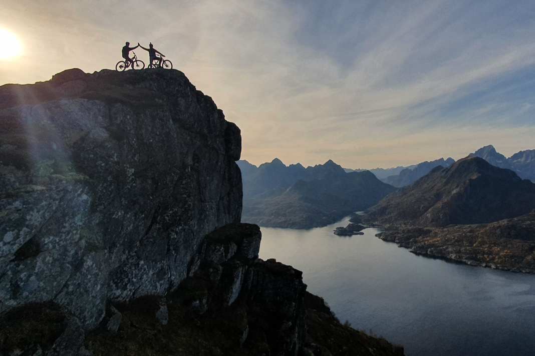 High Five an der Klippe: Vater und Sohn auf Trail- Suche in Senja. Wegen des Golfstroms herrschen angenehme Temperaturen – im Sommer bis 30 Grad.