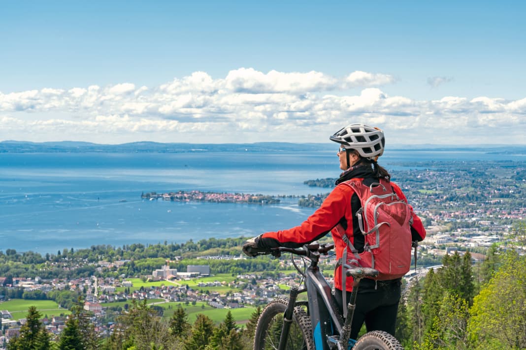 Radreise Bodensee: In der Ferne erblickt diese Radfahrerin vom Bodenseeufer die Schweizer Berge.