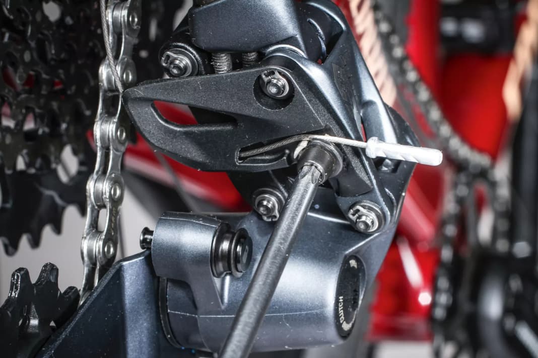 1 Schaltzug lösen: Schalten Sie aufs kleinste Ritzel der Kassette und lockern Sie die Befestigungsschraube des Schaltzugs. Bevor Sie den Stahlzug entfernen, prägen Sie sich nochmals ein, wie er am Schaltwerk befestigt ist.