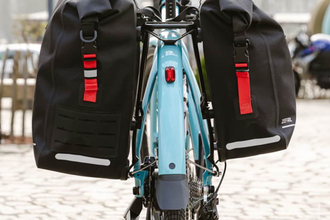 Zéfal hangs his two new panniers on his bike...