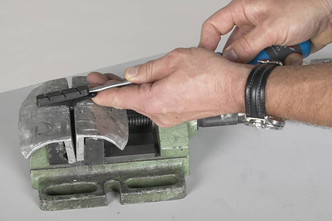 1. Beläge von Campa-Bremsen sind aufwendiger zu wechseln, da die Beläge nicht von Sicherungsschrauben, sondern von einer sehr engen Führung gehalten werden. Spannen Sie den Belag-Träger mit eingedrehter Schraube in den Schraubstock und schieben Sie den Belag einen Zentimeter heraus.