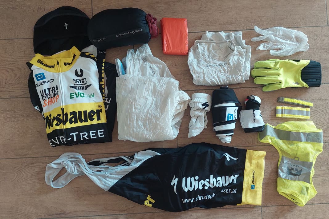 Kleidung & Schlaf-Equipment: Thermomütze, Thermo-Trikot, Regenjacke, Baselayer, Socken, Bib Short, Beinlinge, Armlinge, Winterhandschuhe, Latex-Handschuhe als Regenschutz, reflektierende Weste und Straps, Notfallbivi und Schlafsack
