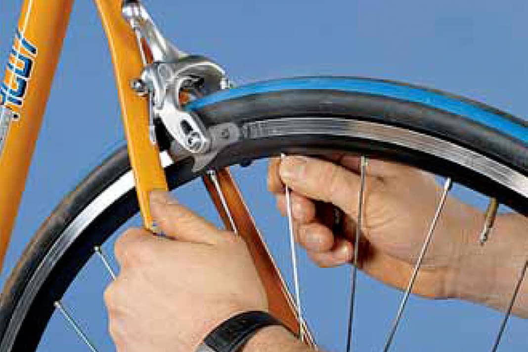 1. Zur Überprüfung des Lagerspiels heben Sie das Rad so hoch, dass sich das Laufrad frei drehen kann. Umfassen Sie die Felge oder eine Speiche im Bereich der Bremsklötze und bewegen Sie die Felge leicht quer zur Fahrtrichtung. Kippt die Felge dabei, müssen Sie das Lagerspiel nachstellen. Kontrollieren Sie aber zuerst den Sitz des Schnellspanners, bevor Sie zum Werkzeug greifen.