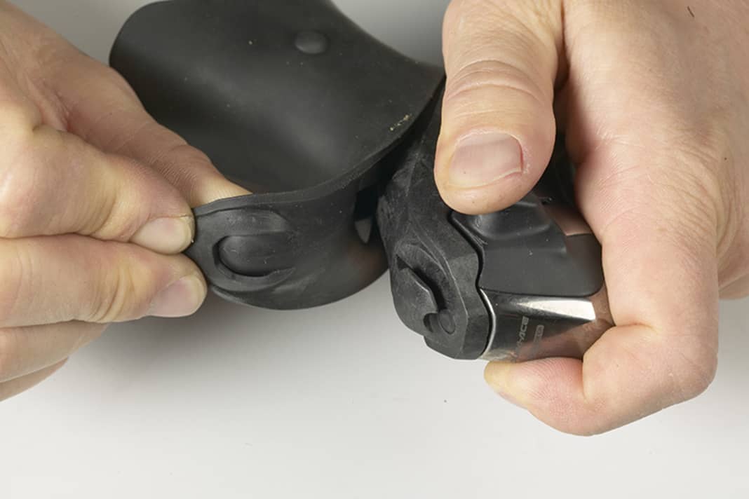 1. Ziehen Sie den Griffgummi auf der Oberseite des vom Lenker demontierten Hebels etwas nach vorn und oben, damit der Gummi aus der Befestigungsnut herausgleitet, und anschließend nach hinten von der Hebelarmatur herab.