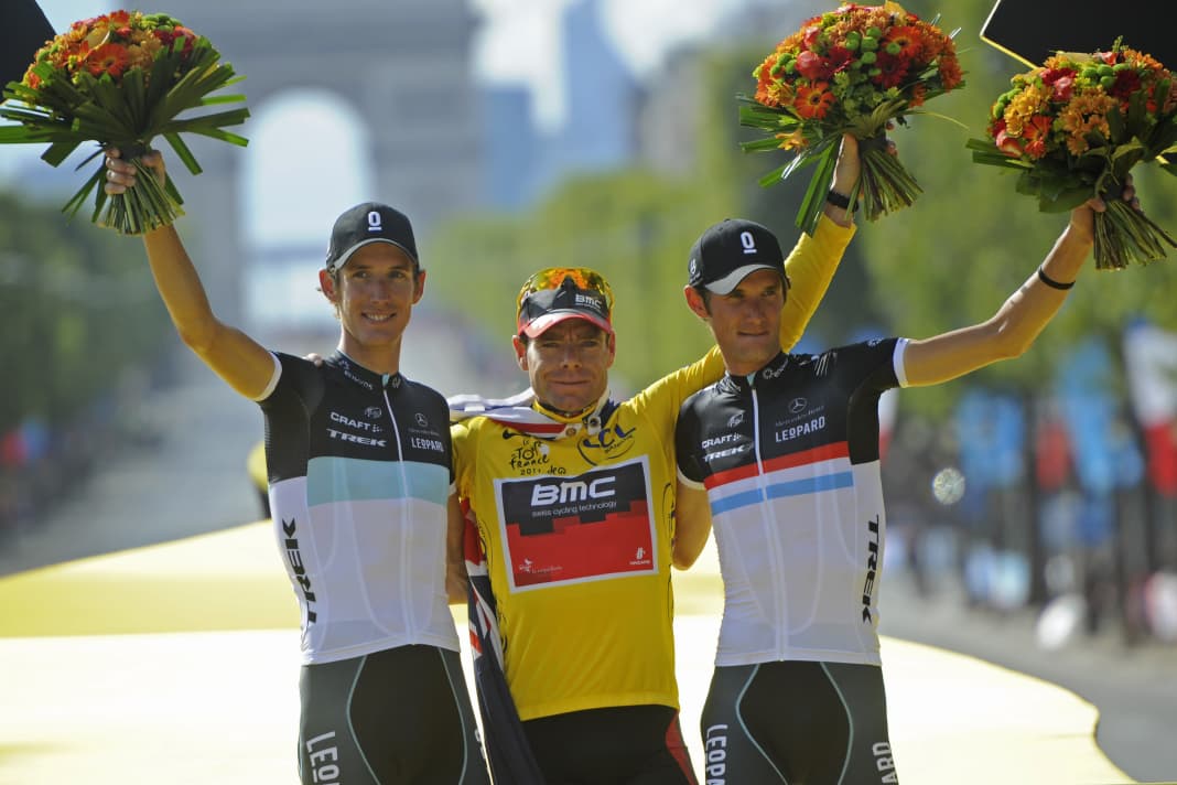 Andy Schleck (l.) and brother Fränk (r.) with winner Cadel Evans on the podium of the 2011 Tour de France.