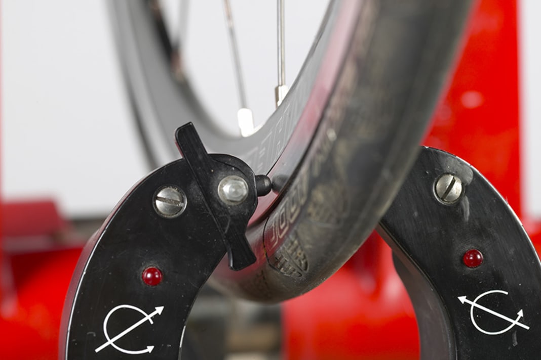 Démontez la roue et fixez-la sur un support de centrage. Approchez les pointeurs du support de centrage à environ un millimètre des flancs de la jante. Faites tourner lentement la roue et observez si la jante frôle un capteur.