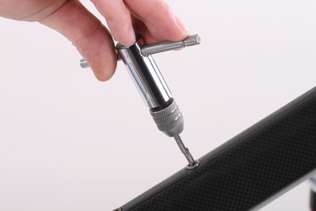 Beschädigte Gewinde können eventuell nachgeschnitten werden. Setzen Sie den mit Schneidöl versehenen Gewindebohrer senkrecht zum Rohr und in der Flucht der Blindnietmutter an. Schneiden Sie das Gewinde vorsichtig nach. Ist das Gewinde irreparabel defekt oder der Niet lose, muss er ersetzt werden.