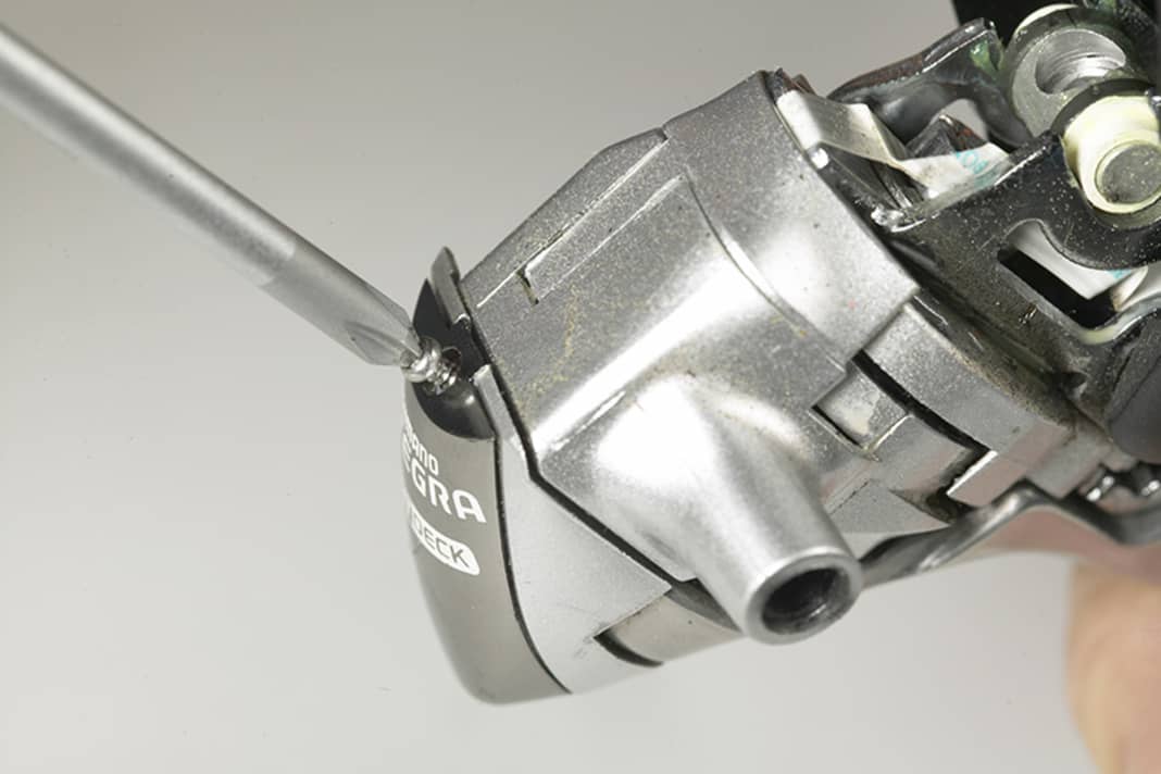 1. Ziehen Sie den Bremsgriff, das legt eine Kreuzschlitzschraube frei. Schrauben Sie diese vollständig heraus.