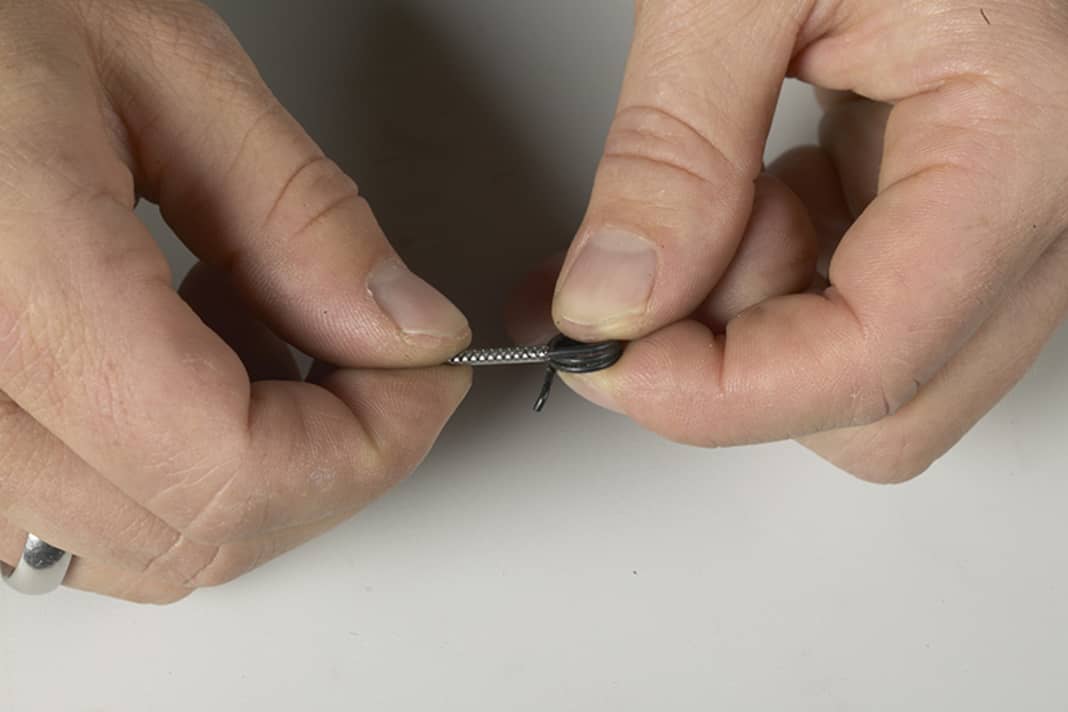 1. Setzen Sie das rohrförmige Spezialwerkzeug (normalerweise im Originalkarton enthalten) auf das in Wickelrichtung abstehende lange Ende der Feder, die den Bremshebel nach dem Bremsvorgang zurückstellt.