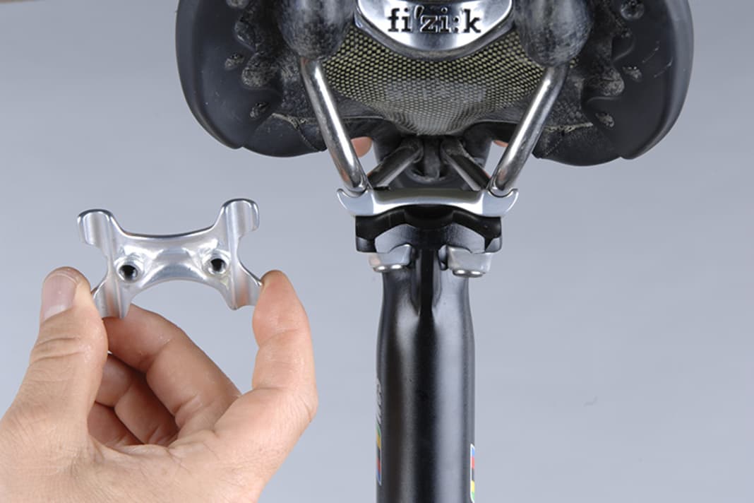 1. Vorteil dieser Technik ist die geringere Bruchanfälligkeit der zwei Schrauben. Demontieren Sie beide Schrauben so weit, dass Sie die obere Halbschale abnehmen können. Legen Sie erst das Sattelgestell auf die untere Halbschale und dann die obere Halbschale wieder darauf.