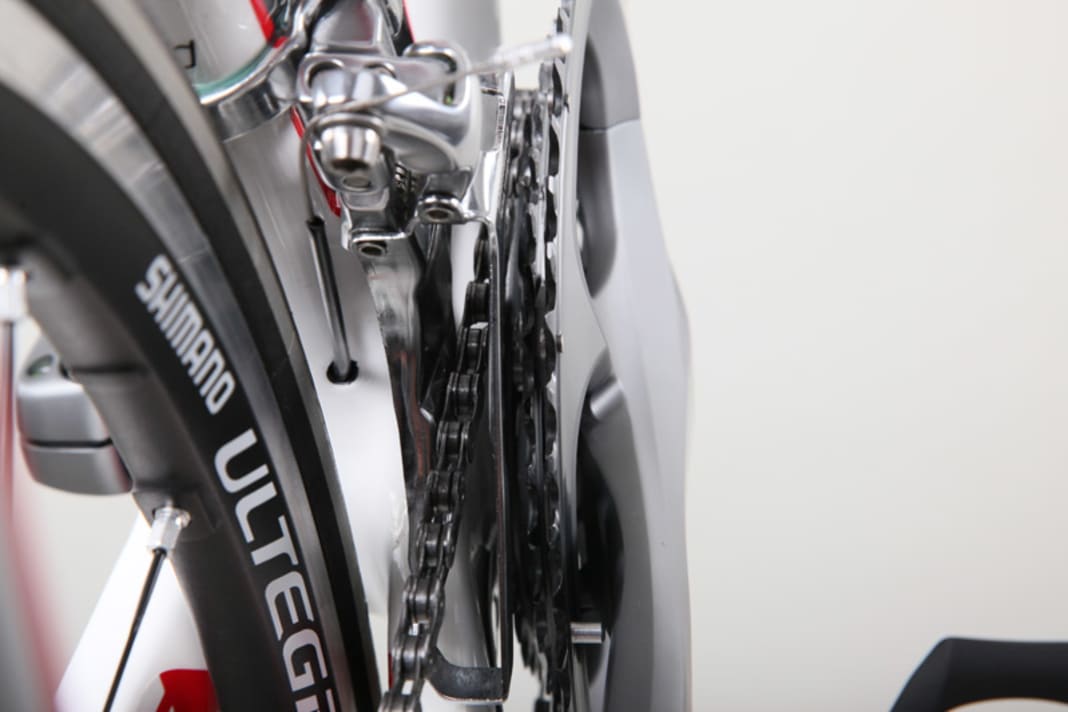 1. Kontrollieren Sie den Abstand des inneren Leitblechs zur Kette bei entspanntem Zug (Kette auf dem kleinen Blatt. Drehen Sie dazu die Kurbel – die Kette darf nicht streifen, der Abstand muss jedoch so klein wie möglich sein. Mehr als ein halber Millimeter Abstand kann dazu führen, dass die Kette beim Schalten abgeworfen wird. Stellen Sie den Abstand mit der innen liegenden Endanschlagschraube ein.