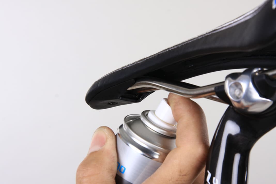 Sprühen Sie Schmierspray – in diesem Fall solches mit Silikonanteil – dorthin, wo die Satteldecke auf das Gestell aufgesteckt ist. Lassen Sie es einwirken, kontrollieren Sie erneut.