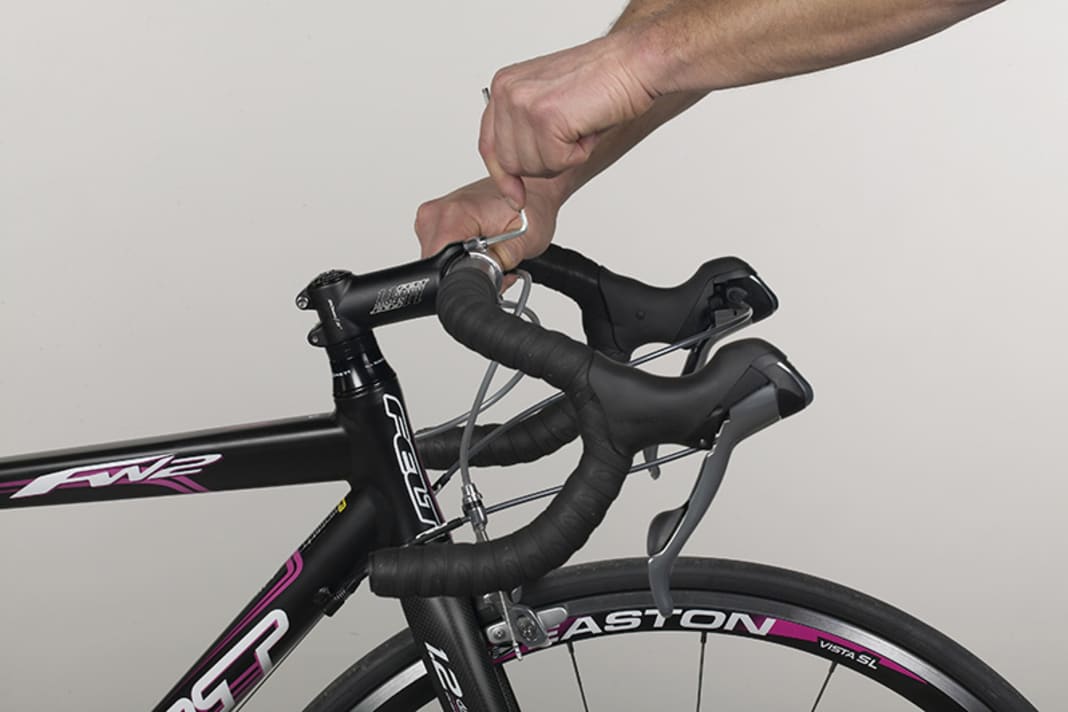 1. Lösen Sie die Schrauben vorne am Vorbaudeckel zwei bis drei Umdrehungen. Der Lenker muss sich jetzt ohne Widerstand verdrehen lassen. Richten Sie den Lenker so aus, dass die Lenkerenden parallel zum Boden oder leicht nach unten zeigen. Die Oberkanten der Bremsgriffe sollten waagerecht ausgerichtet sein und keinesfalls nach unten zeigen.