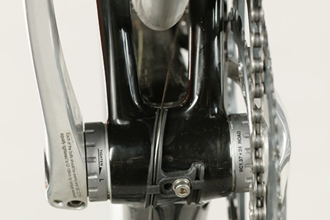 1. Gegen Zugreibung am Tretlagergehäuse helfen Kunststoffschienen, wie sie mittlerweile von den meisten Rahmenbauern serienmäßig montiert werden. Sie liegen auch den Schaltgriffen bei. Wichtig: Shimano gibt serienmäßig Fett in die Zughüllen – und zwar von der Seite mit dem Schriftzug her. Kürzen Sie die Hülle also nur am anderen Ende! Halten Sie das beschriftete Hüllenende an den Ausgang im Griff und schlagen Sie den Lenker ein, um die benötigte Länge bis zu den Anschlägen am Rahmen zu ermitteln. Der Schaltzug darf dabei nicht abgeknickt werden.