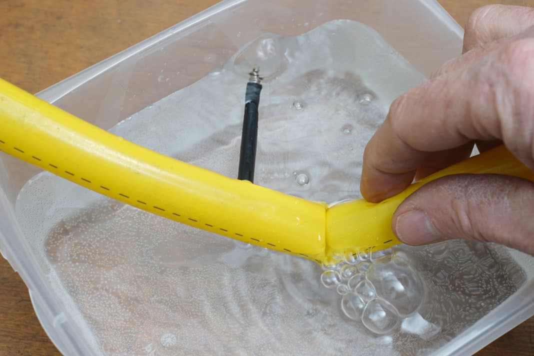 Recherche de trous dans un bain d'eau : l'eau ne jaillit pas toujours aussi sauvagement que dans notre défaut préparé. Une faible surpression (max. 0,3 bar) rend difficile la détection des plus petits trous dans le TPU.