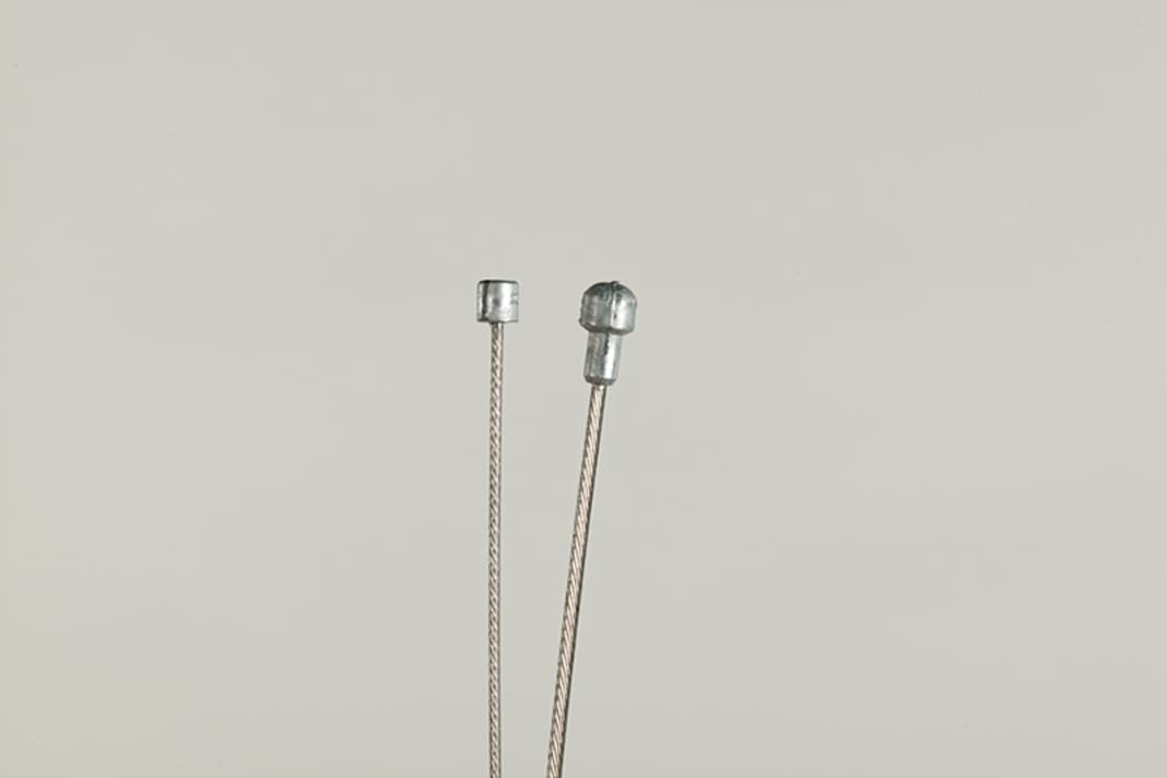 Info 1 : Les câbles de dérailleur et les câbles de frein ne sont pas interchangeables - ils diffèrent par le diamètre du câble intérieur, la forme de la tête et la gaine extérieure.

Info 2 : La longueur des gaines extérieures des câbles de dérailleur doit être adaptée. La partie courte de la gaine extérieure qui va de la base de la chaîne au dérailleur arrière ne doit pas être modifiée.

Info 3 : Campagnolo place le câble le long du guidon, les courbures entraînent une friction accrue. Sur les cadres de petite hauteur, il reste peu de place pour poser les câbles sans les plier - croisez les câbles : le câble du dérailleur avant passe sur le côté droit du tube diagonal, celui du dérailleur arrière sur le côté gauche. Croisez ensuite à nouveau les câbles sous le tube diagonal.