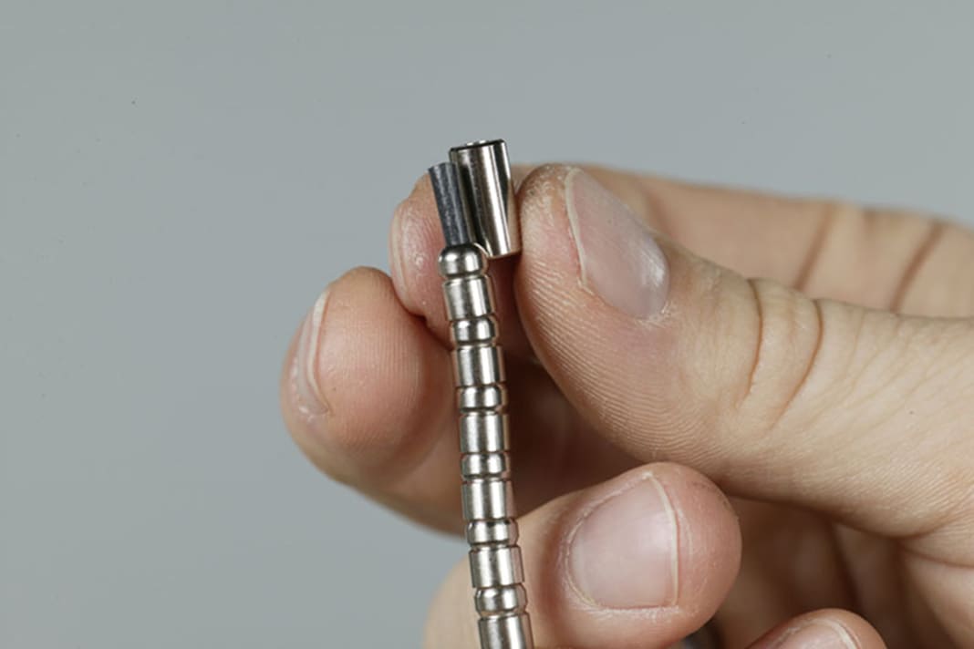 1. slide the beads threaded onto the plastic tube to the end so that you can slide on the end sleeve and possibly a single bead. The plastic tube should end two to three millimetres inside the end piece. There are shorter sleeves at one end of the pull than at the other; the shorter ones should point towards the handle.