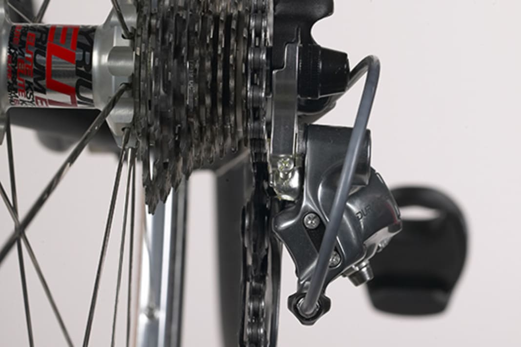 1. shift the chain to the smallest chainring or sprocket with the front derailleur and rear derailleur until no more click stops are triggered when shifting down. The shift cables are then completely slack. Look at the rear derailleur from behind. The guide roller of the rear derailleur must be positioned exactly under the smallest sprocket, the chain then forms a straight line. If this is not the case, you must adjust the position using the end stop screw.