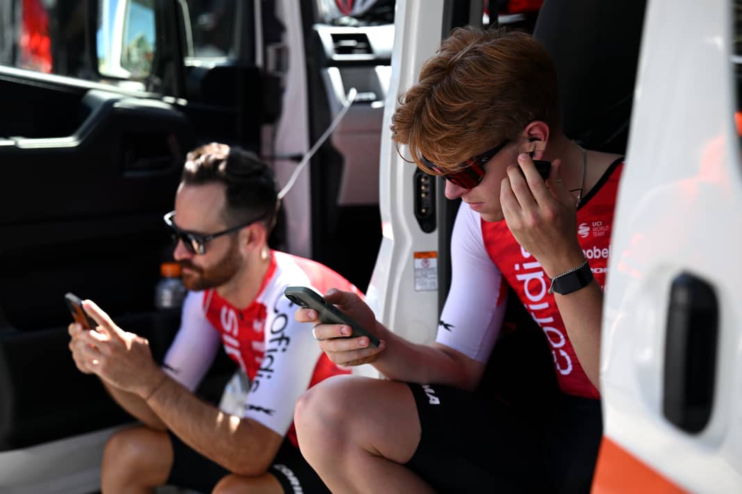 Waiting for the start. Simon Geschke (l.) and Oliver Knight from Cofidis quickly check their mobile phones.