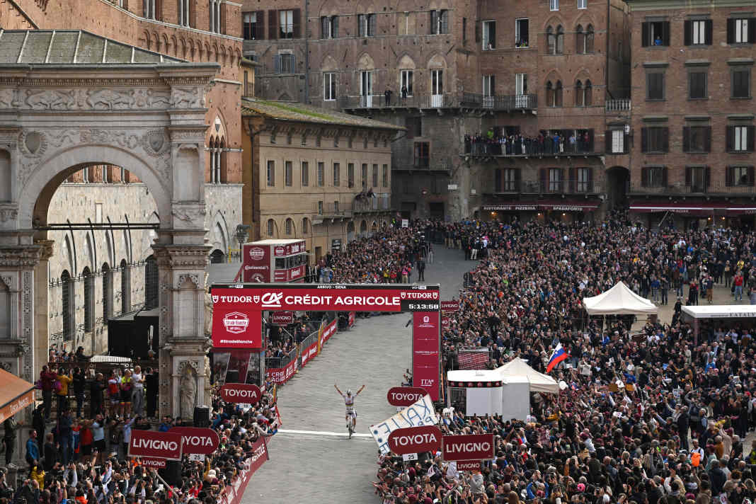 Tadej Pogacar crosses the finish line in Piazza del Campo | Getty Images