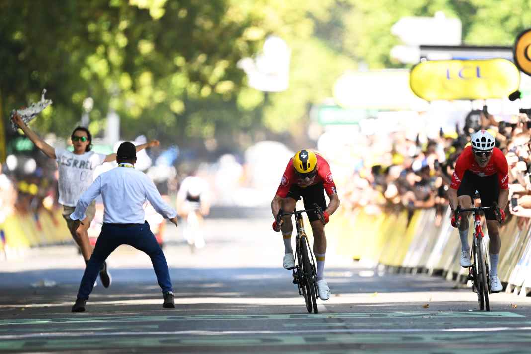 Double duel on the last metres of the 11th stage in Toulouse: While Jonas Abrahamsen and Mauro Schmid duel for the stage win, a security guard clears a protester out of the way with a tackle.