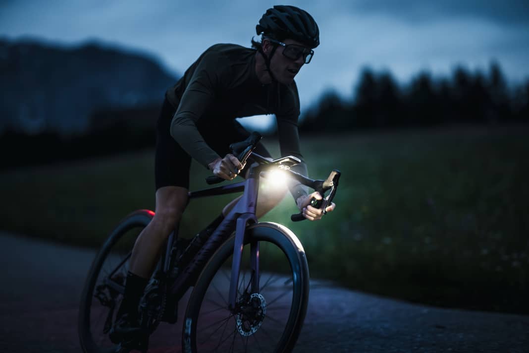 Rennrad mit Akkuscheinwerfer am Cockpit