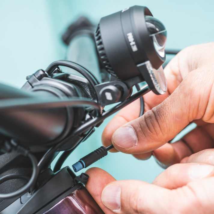 Für die Stromversorgung wird der Stecker an der vorbereiteten Steckdose oberhalb der Steuersatz-Lagerschalen angeschlossen.