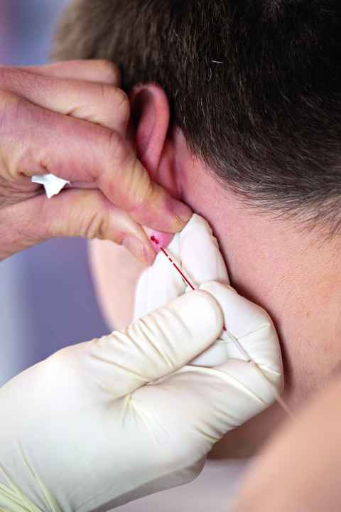 Training expert Stefanie Mollnhauer takes a drop of blood from his earlobe several times during the test to determine the lactate level.