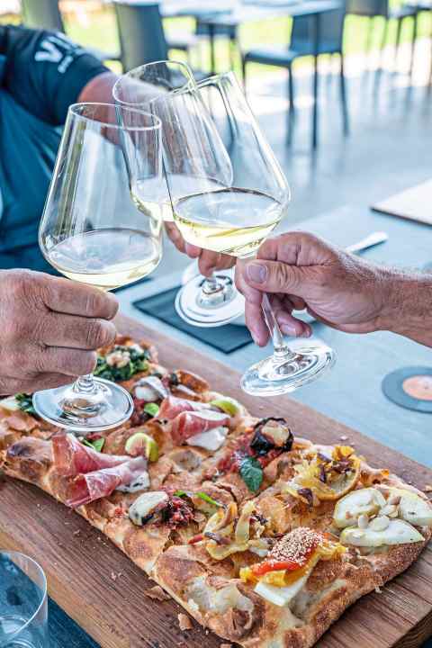 Leckere Pinsa und kühler Weißwein: Kulinarisch bleiben auf einer Radreise durch die Emilia-Romagna keine Wünsche offen.