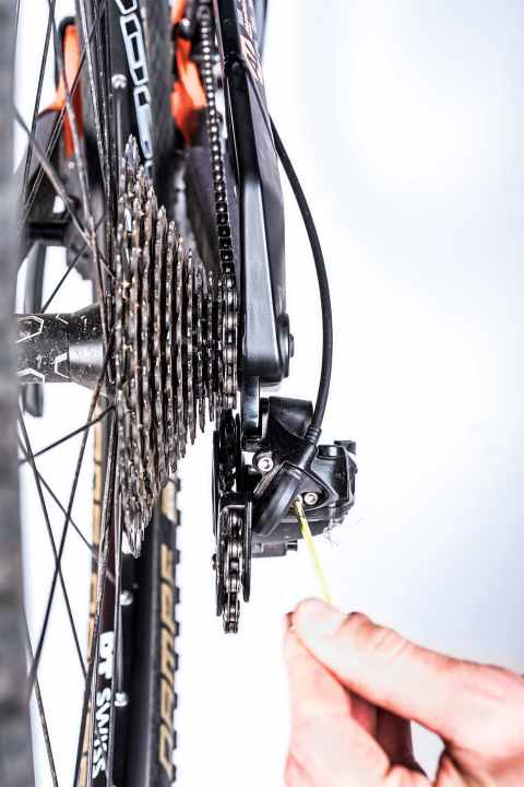    Oberes Ritzel einstellen: Richtig lästig wird es, wenn die Kette zwischen großes Ritzel und Speichen fällt. So stellen Sie den Anschlag korrekt ein: Schalten Sie auf das größte Ritzel und drehen Sie die äußere Begrenzungsschraube so weit, bis das Leitröllchen exakt unterhalb des großen Ritzels steht. Schraube nach rechts drehen, limitiert den Schaltkäfig nach links und umgekehrt.