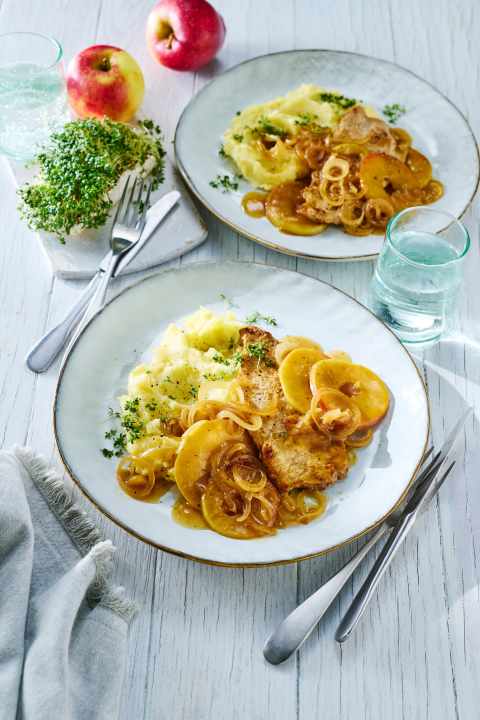 Herbstliches Schweineschnitzel mit Apfel kommt mit Röstzwiebeln und Kartoffelbrei besonders gut.