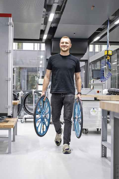 Lars Funke carries two solid aluminium wheels to the test bench. New mountain bike compounds are first vulcanised onto road bike tyres. This eliminates the influence of the tread on the laboratory measurements.