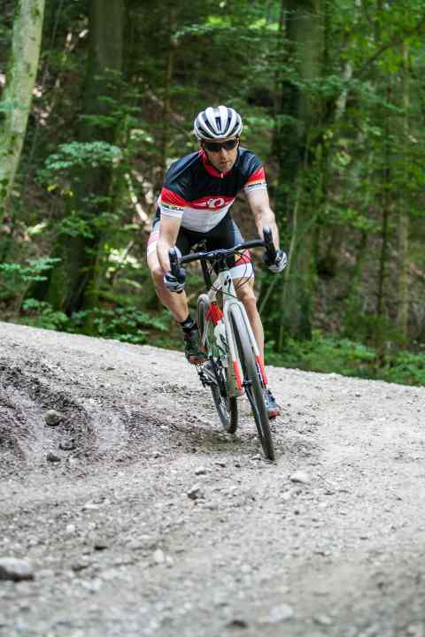 Gravel riding technique: Switch to the inside lane far enough before the bend and use the rise in the centre as a berm like a banked bend on a cycling track.