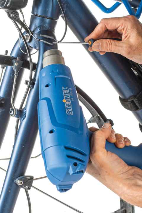 Aktivieren Sie den Schrumpfschlauch mit einem Heißluftfön. Achtung:  Zu viel Hitze lässt die Kabelisolation reißen.