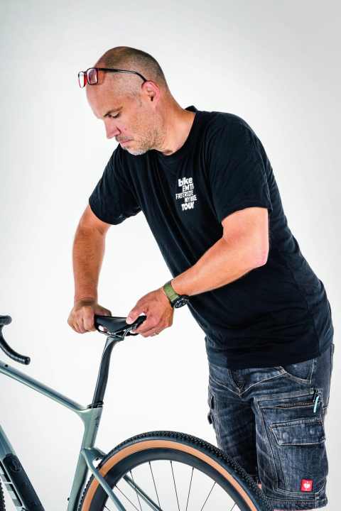 Kontrolle des Sattels und der Stütze: Greif den Sattel an Nase und Heck und versuche, ihn gegenüber dem Rahmen zu verdrehen und zu kippen.