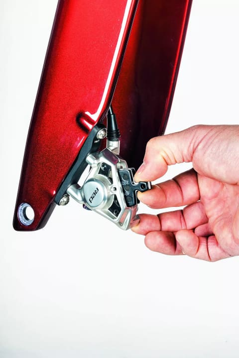 Once the retaining screw for the brake pads has been removed, the pads including the expanding spring, which presses the pads into the correct starting position when the brake lever is opened, can be pulled out upwards with a slight jerk.