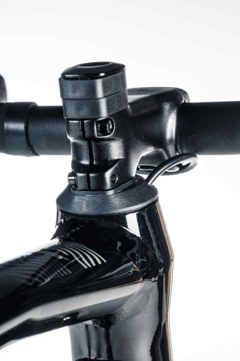 Détail élégant : les câbles et les conduites semi-intégrés entrent à plat dans le capuchon de jeu de direction bas, ce qui confère au cockpit une ligne sportive épurée, assortie au vélo.