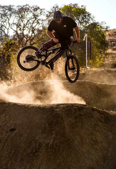 “Ich hab zwar auch ein E-Bike für Touren und Trails, aber mein Sweet Spot sind gebaute Sprungtrails – da fühle ich mich zu Hause.”, sagt Sebastian. Hier schiebt er sein Heck zur Seite.